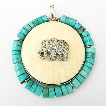 MEDALHA E MARFIM VEGETAL 5CM, COM ELEFANTE EM PRATA E TURQUESAS À VOLTA.